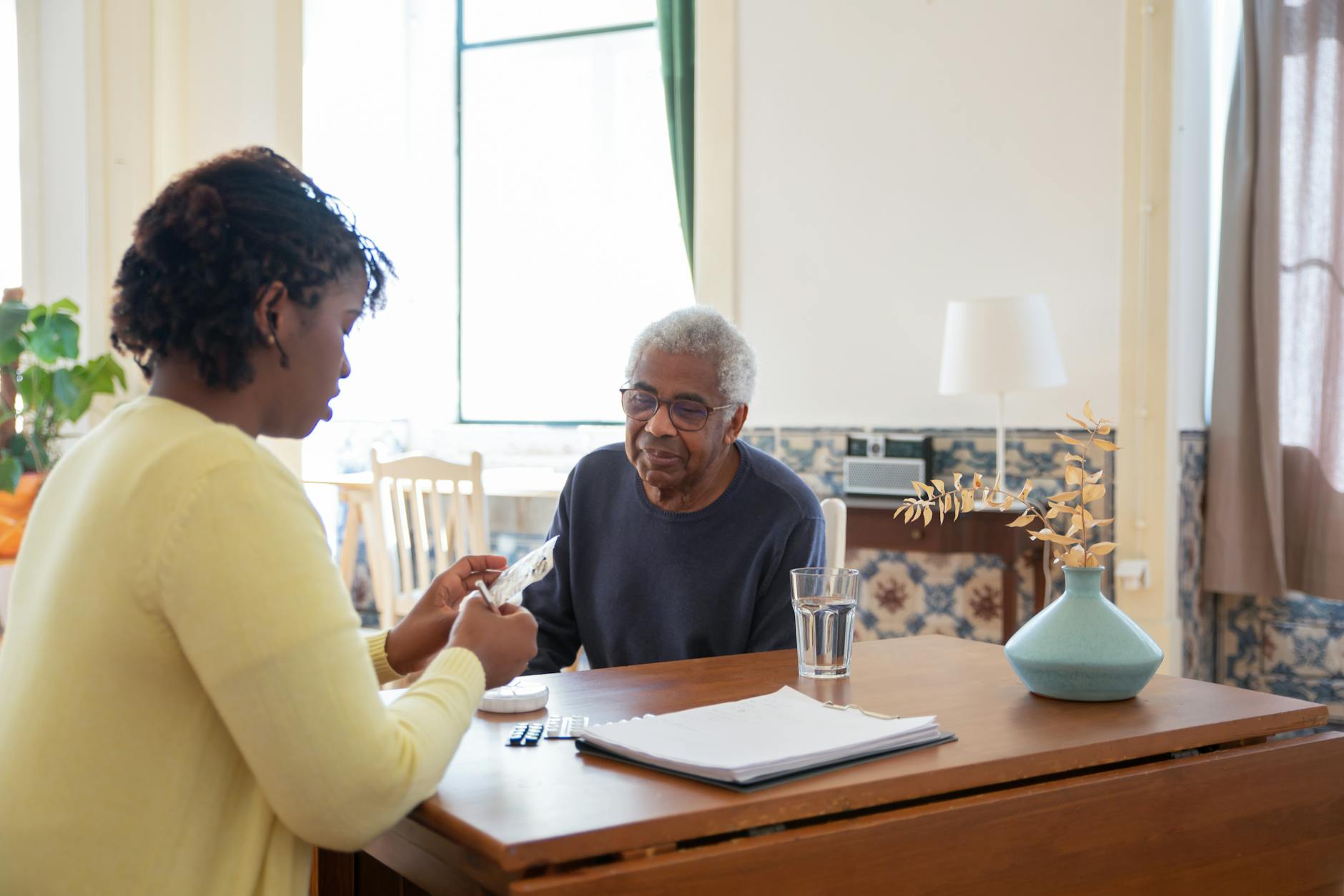 Caring caregiver with elderly resident in bright, warm room